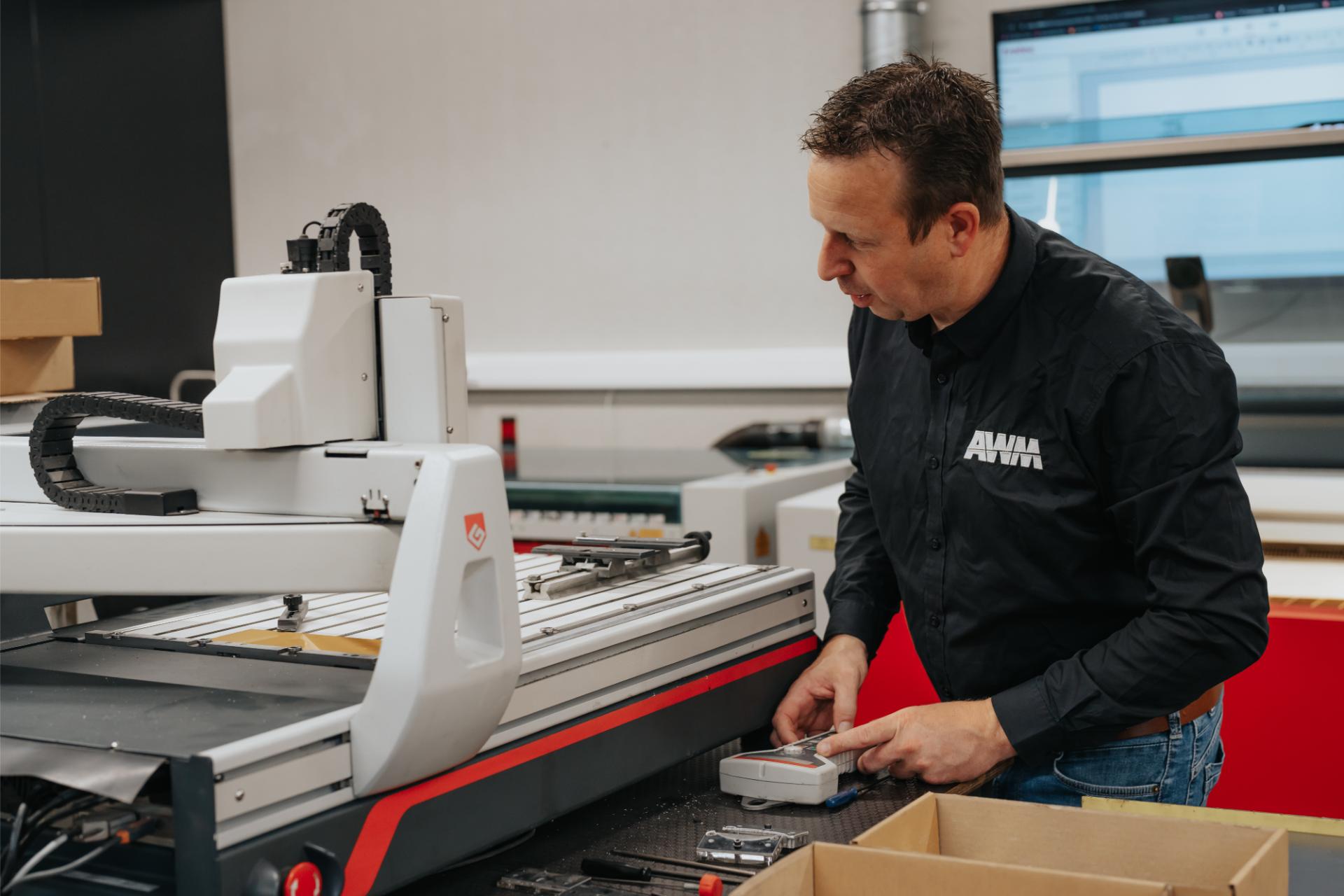 Wouter werkt aan de CNC-graveermachine voor een nauwkeurige afwerking.